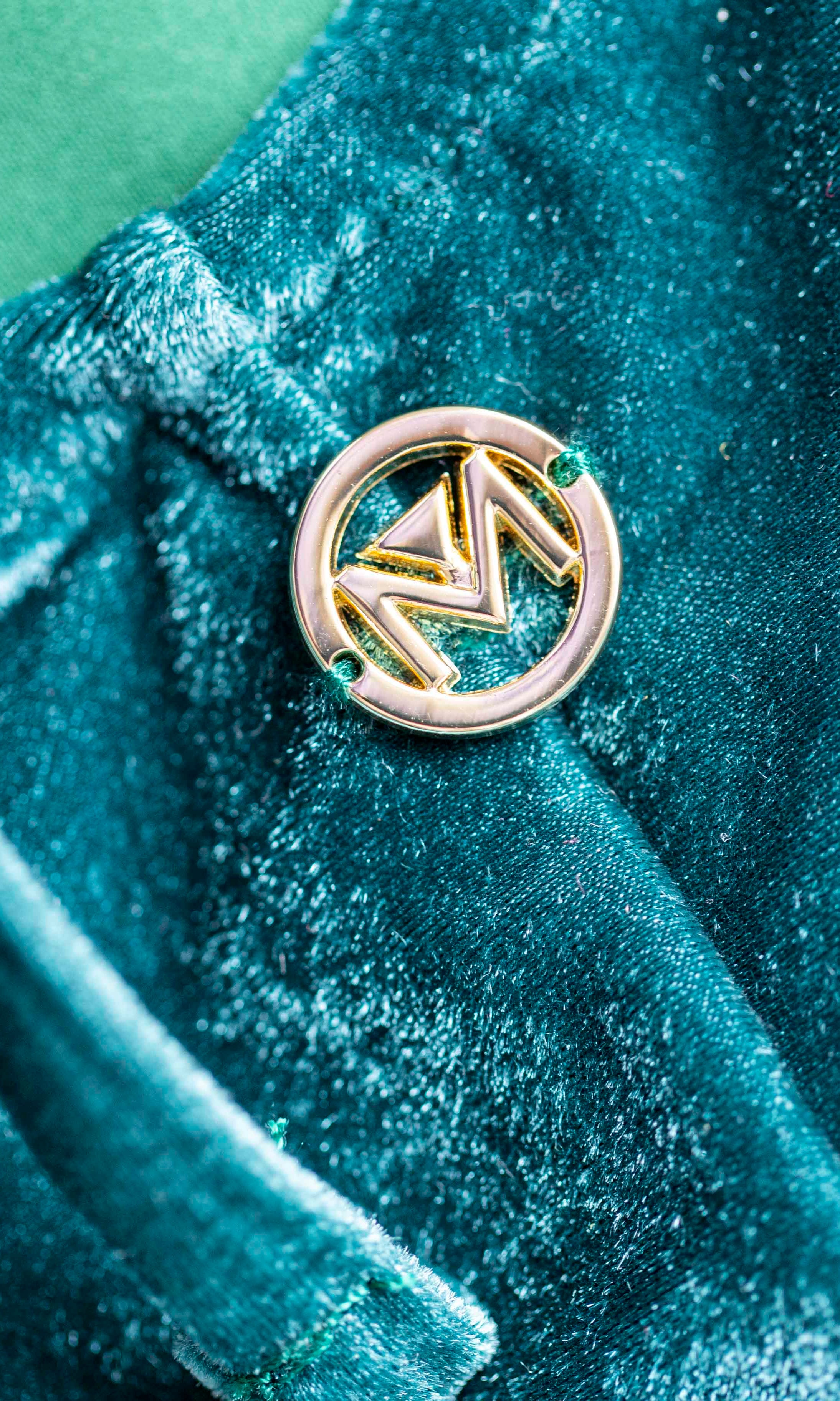 Costume verde in velluto con M sul retro, rappresentativa del nostro brand
