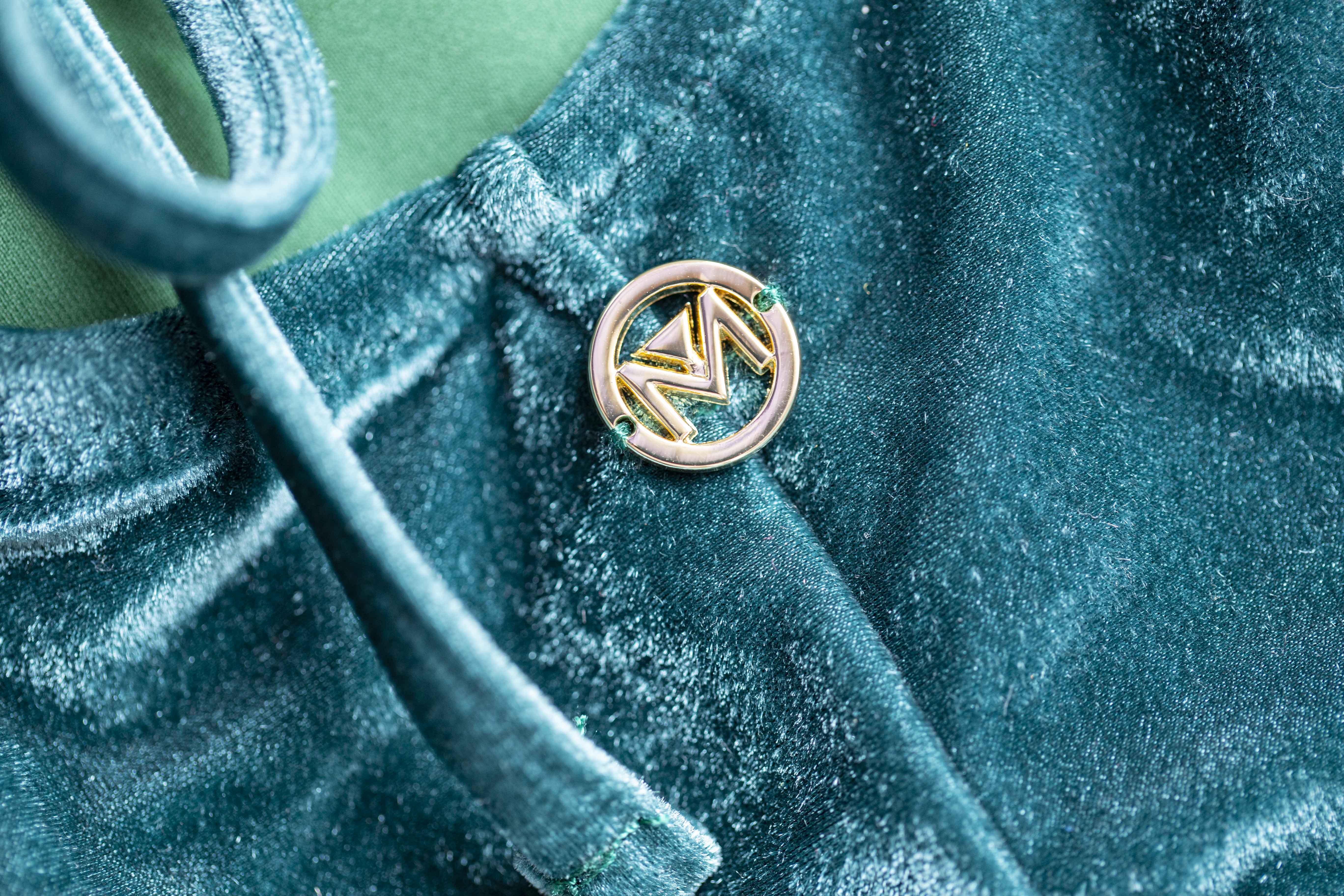 Costume verde in velluto con M sul retro, rappresentativa del nostro brand